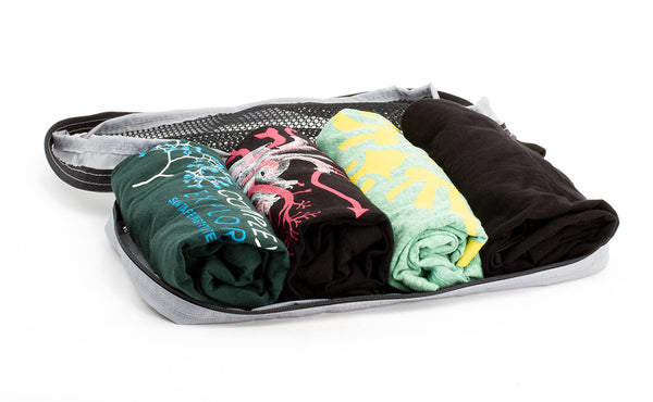 An open Small Tri-Star Packing Cube in Northwest Sky (light grey) 120 Aether filled with rolled shirts.